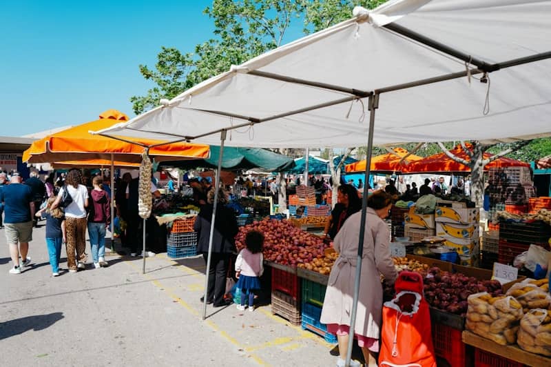 A bustling outdoor market with many people and vendors.