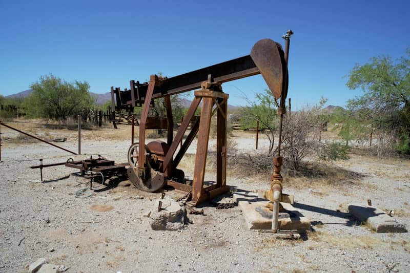 An old oil pump sitting in the middle of the desert