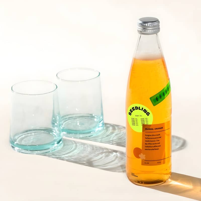 A bottle of seedling drink with two glasses
