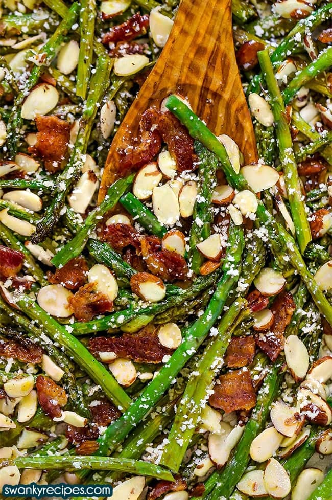 Sautéed asparagus with crispy bacon bits and sliced almonds, topped with shredded cheese.