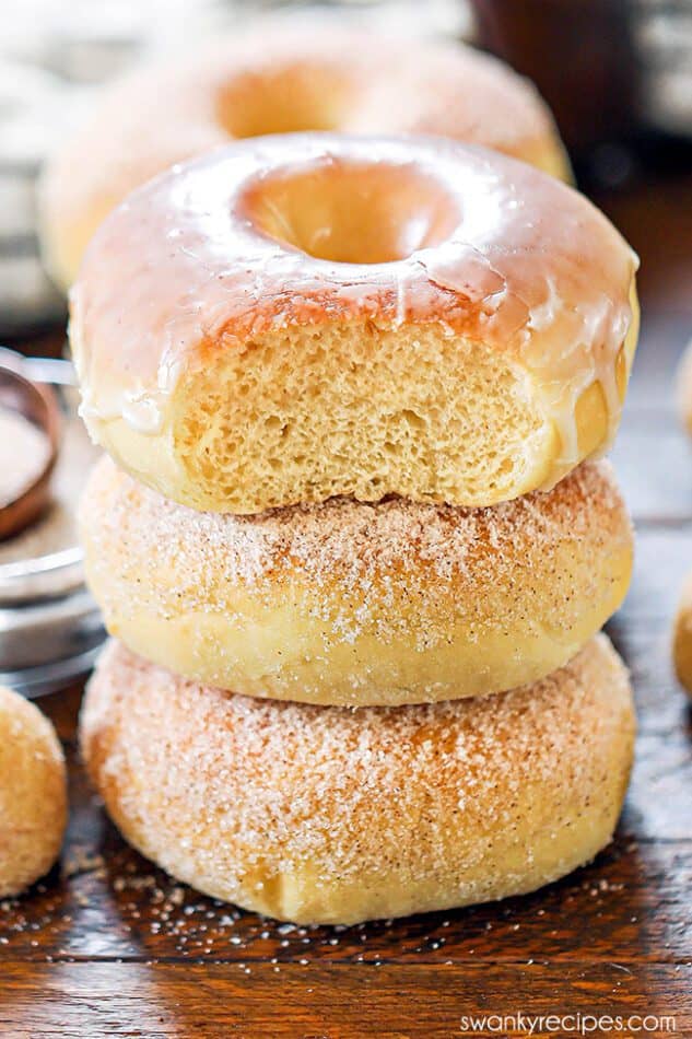 Stack of three air fryer donuts with one glazed donut on top and two sugar-coated donuts below.