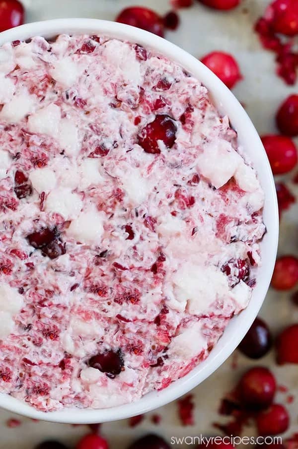 Bowl of creamy cranberry fluff salad with marshmallows and chopped cranberries.