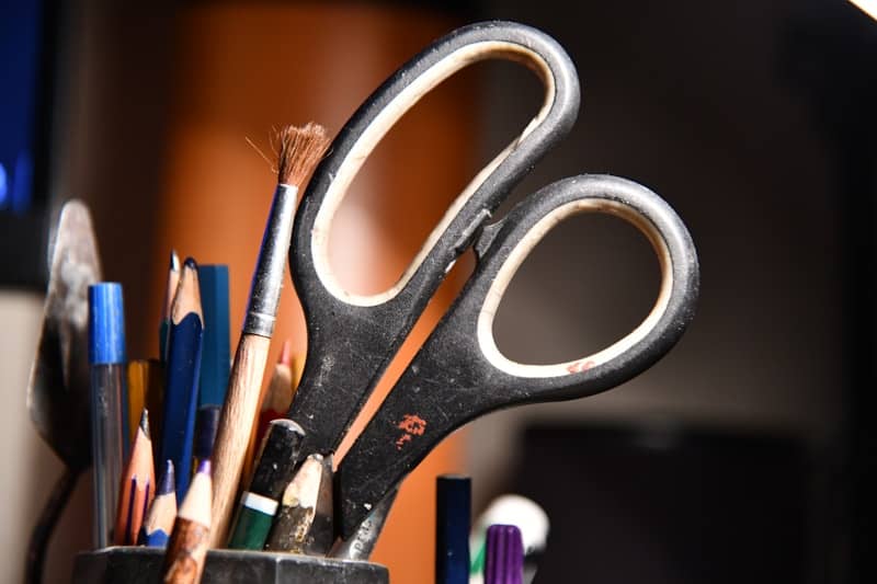 A cup full of pencils and scissors on a desk