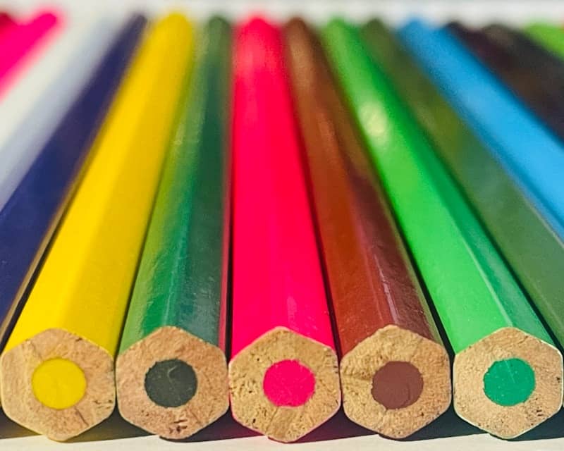 a close up of a row of colored pencils