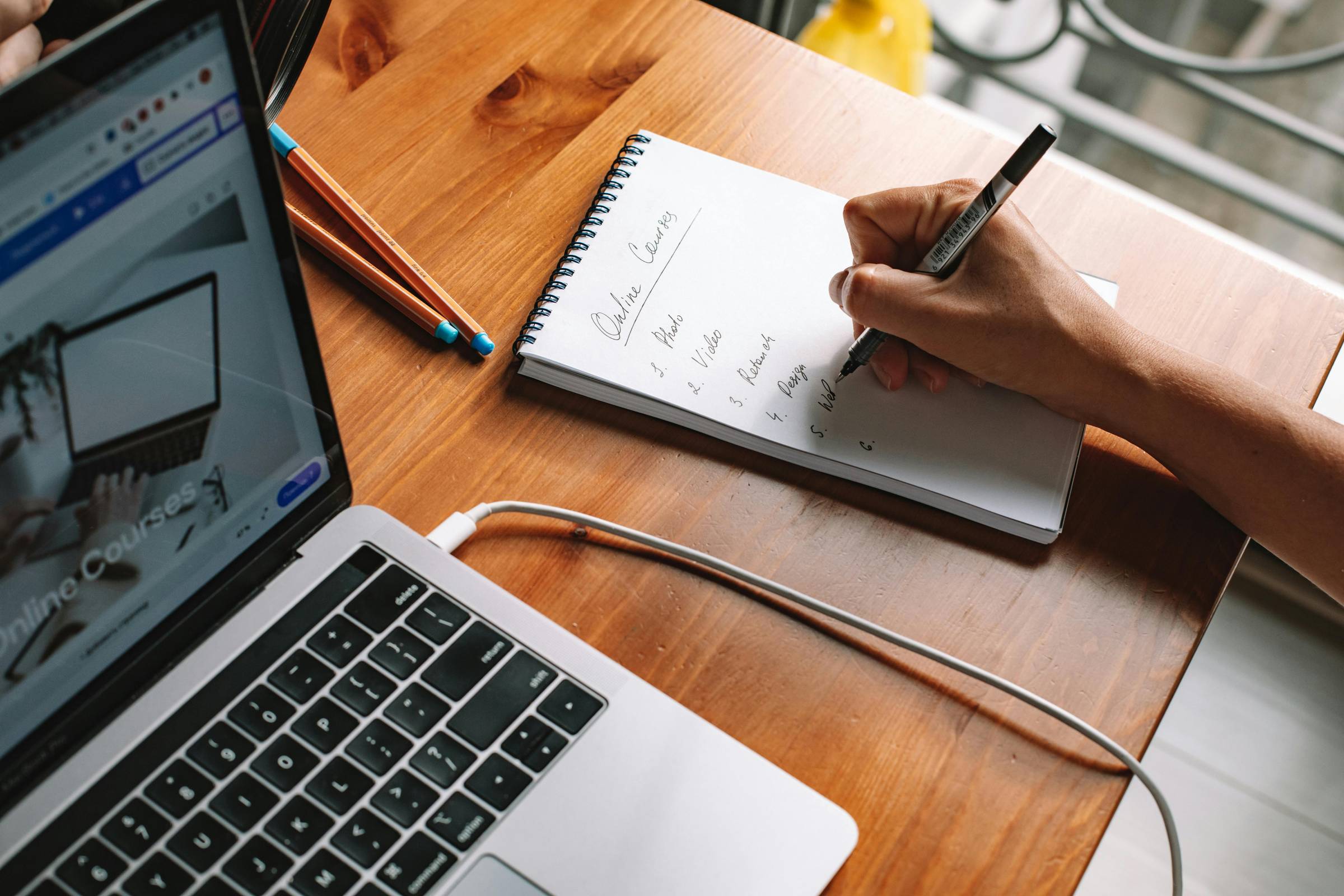 Photo by ROMAN ODINTSOV: https://www.pexels.com/photo/person-writing-on-a-notepad-beside-a-laptop-5912280/