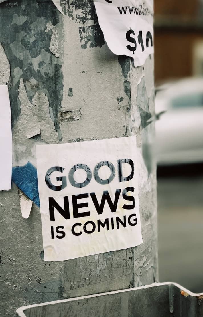 white Good News Is Coming paper on wall