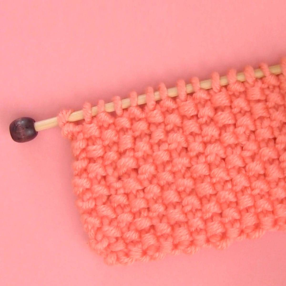 Seed Stitch swatch in orange colored yarn.