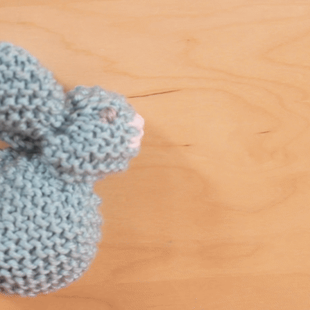 Jumping knitted bunny in blue yarn color. 