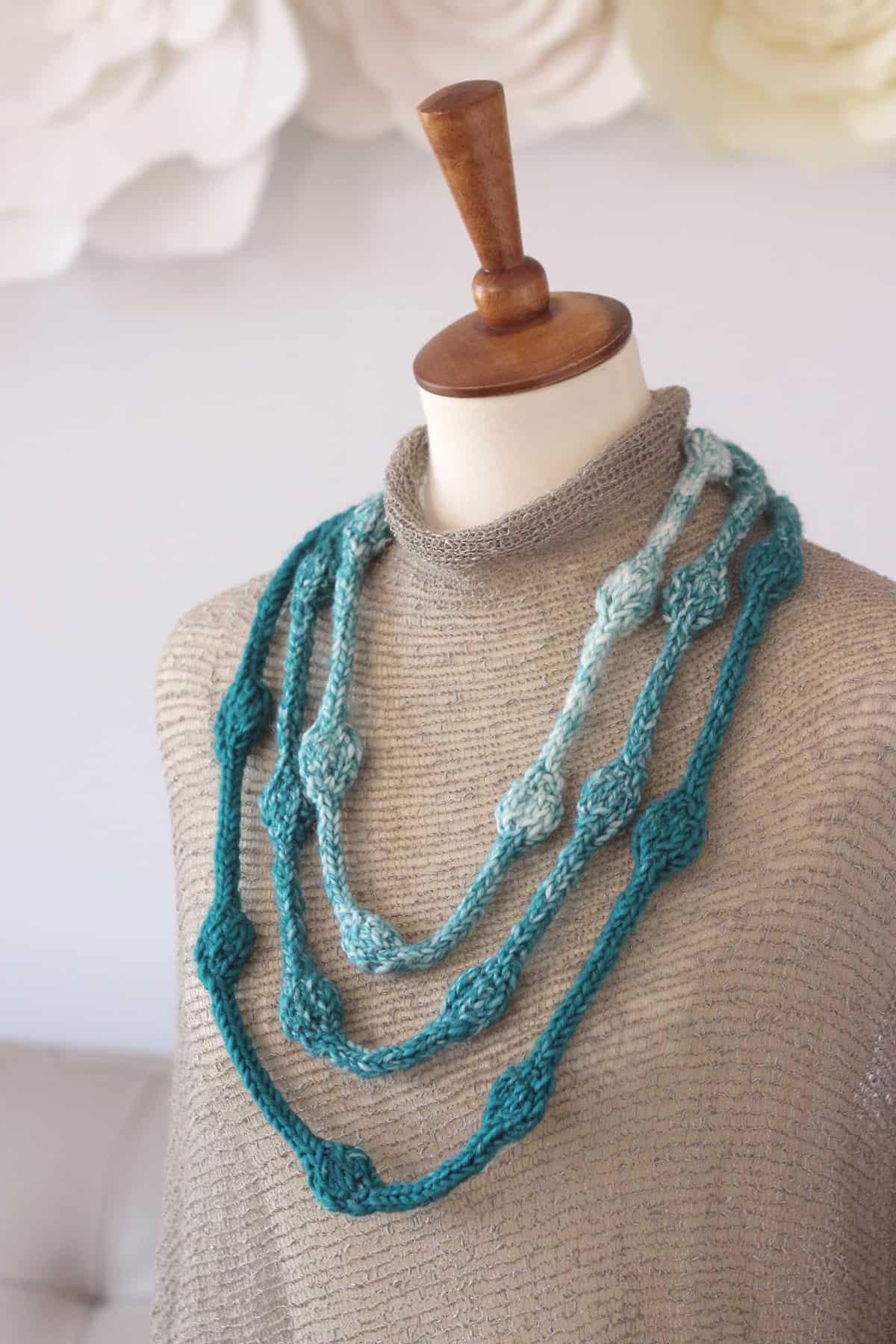 Knitted necklace in blue colors.