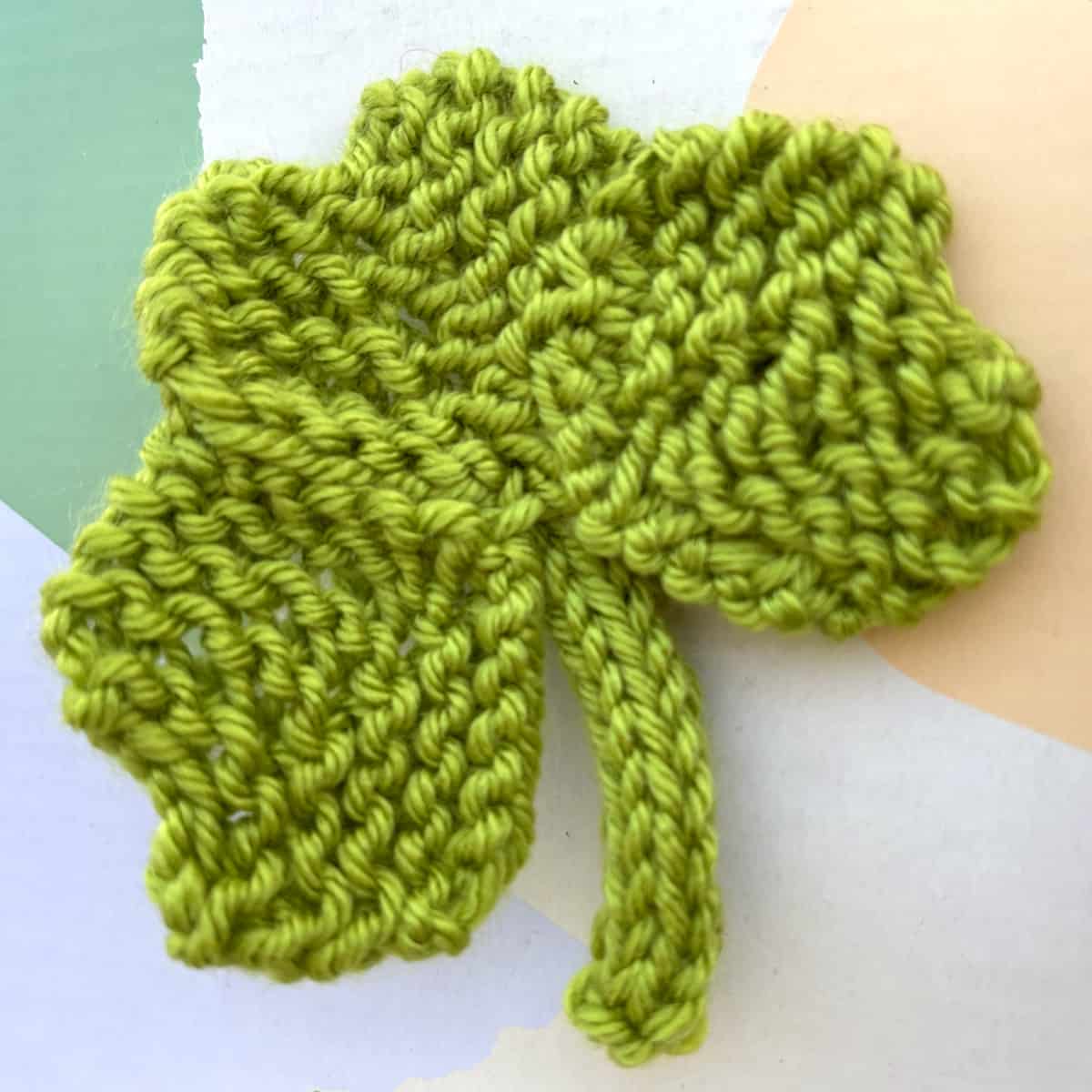 Knitted shamrock shape in green yarn color.