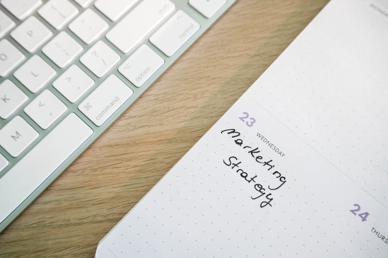 a close up of a notepad on a desk next to a keyboard