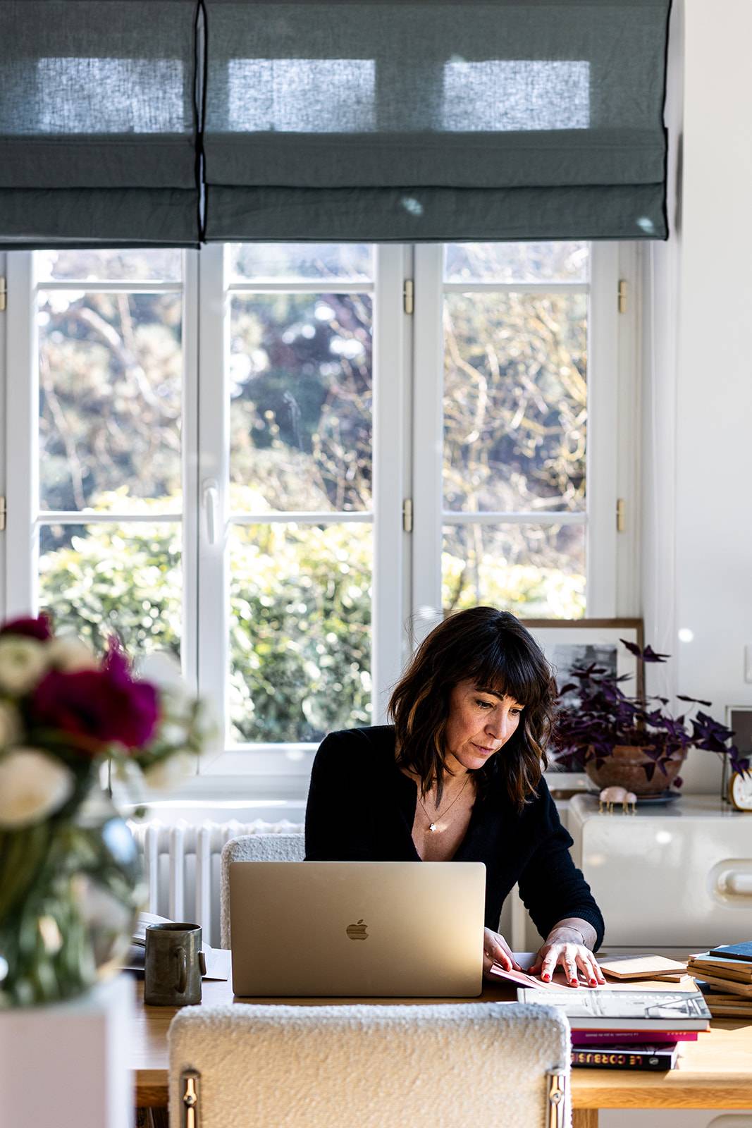 Entrepreneure concentrée à son bureau, travaillant sur son ordinateur dans un cadre calme et structuré.
