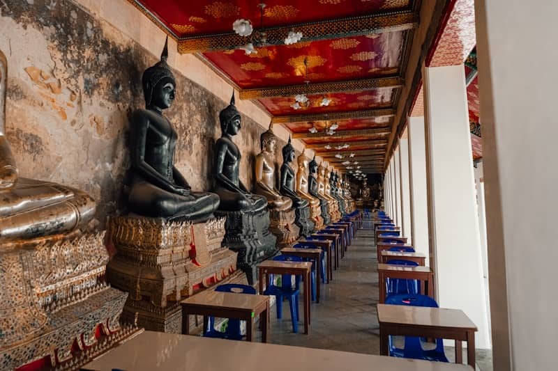 Buddha statues line the corridor of a temple.