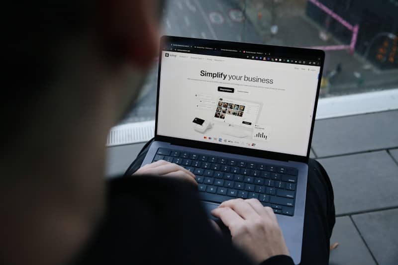 A man sitting on a bench using a laptop computer