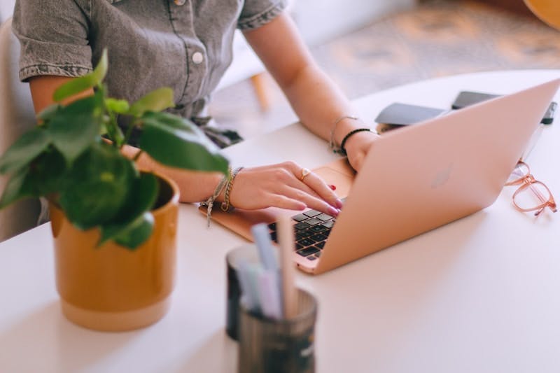 A woman sitting at a table using a laptop computer