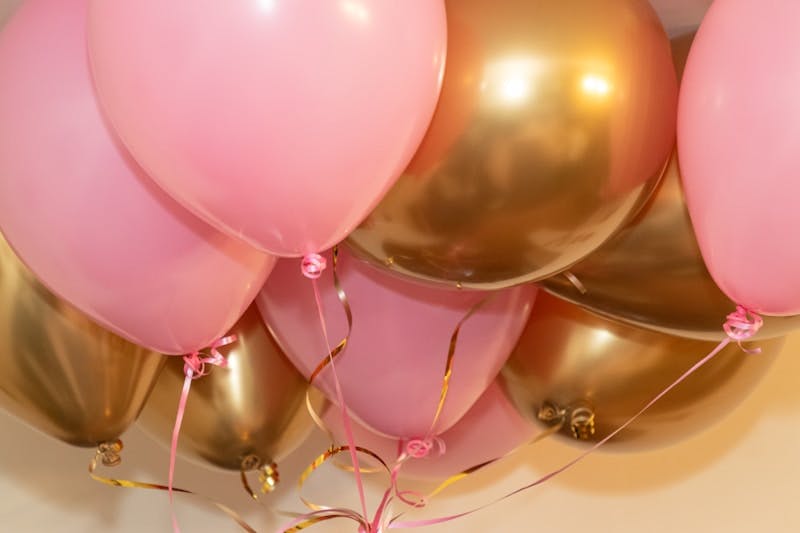 A bunch of pink and gold balloons on a table