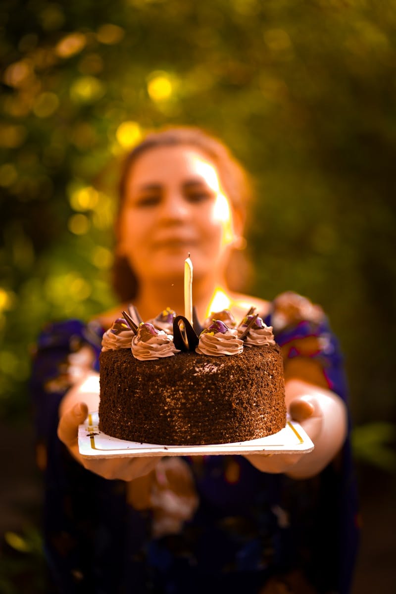 A woman holding a cake with candles on it