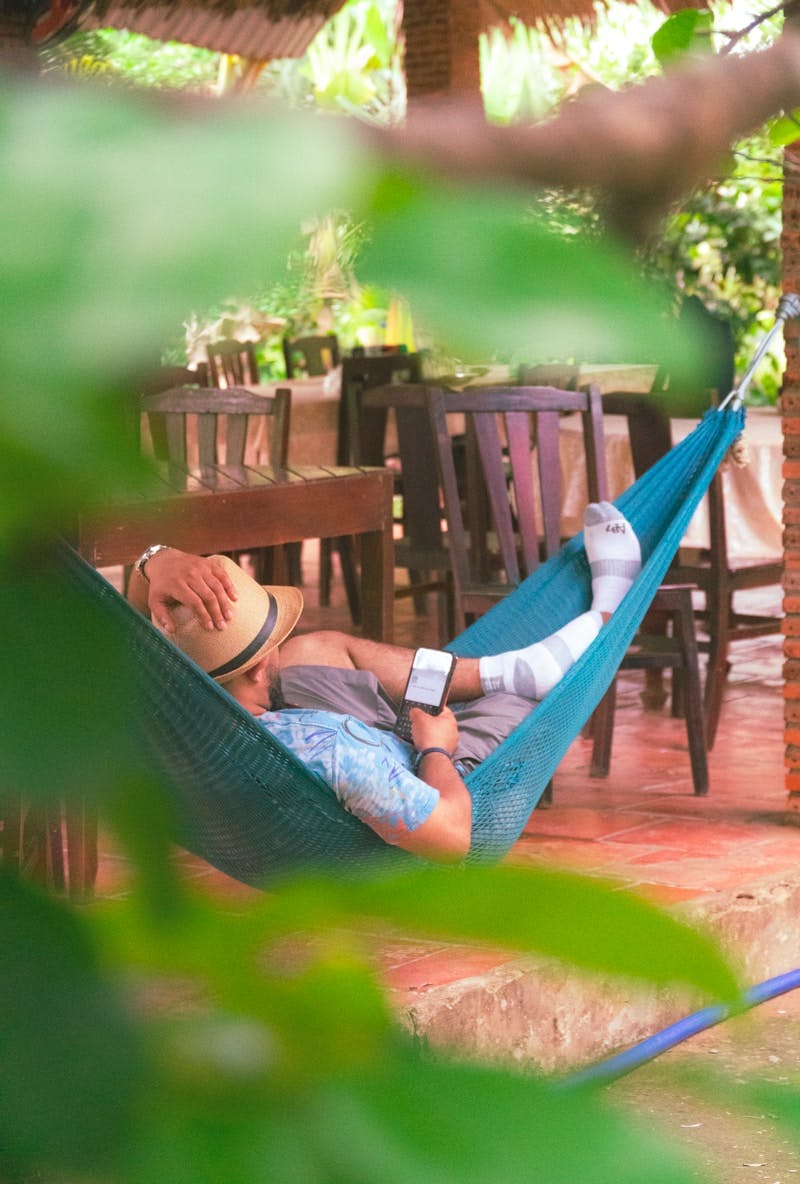 A man laying in a hammock on a patio