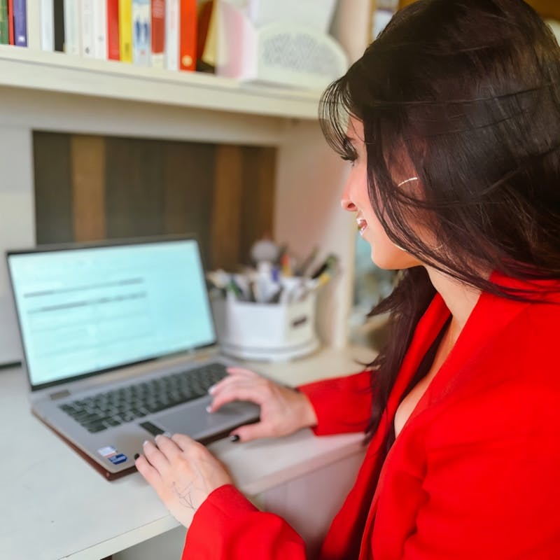 A woman sitting at a desk using a laptop computer