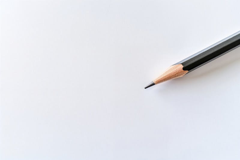 A pencil is laying on top of a piece of paper