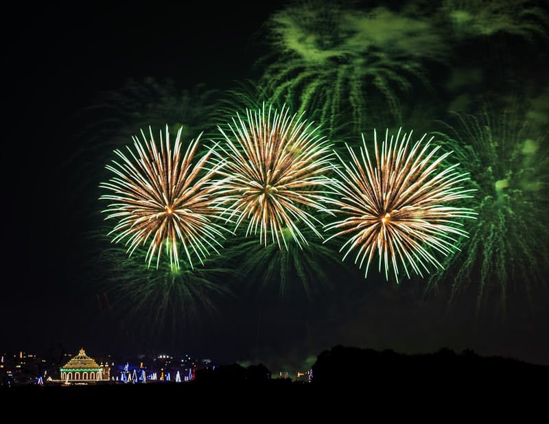 A group of fireworks are lit up in the night sky