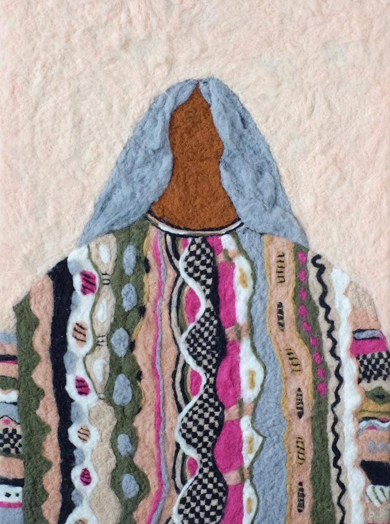 Needle-felted portrait of a person with blue hair and a patterned sweater