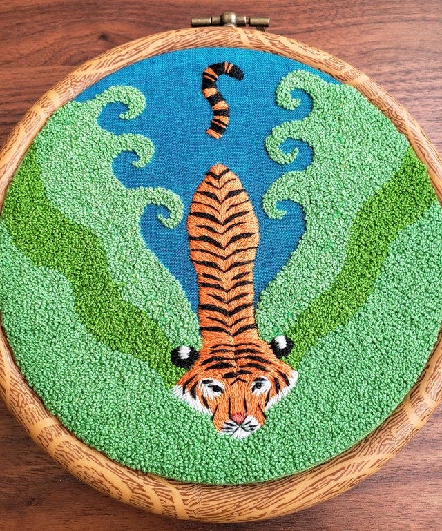 Embroidery of a tiger surrounded by French knot algae