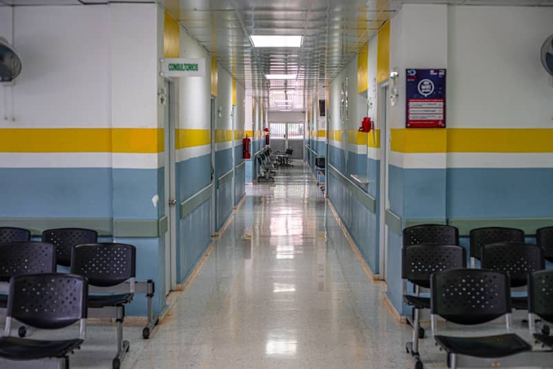 A long hallway with chairs and a clock on the wall