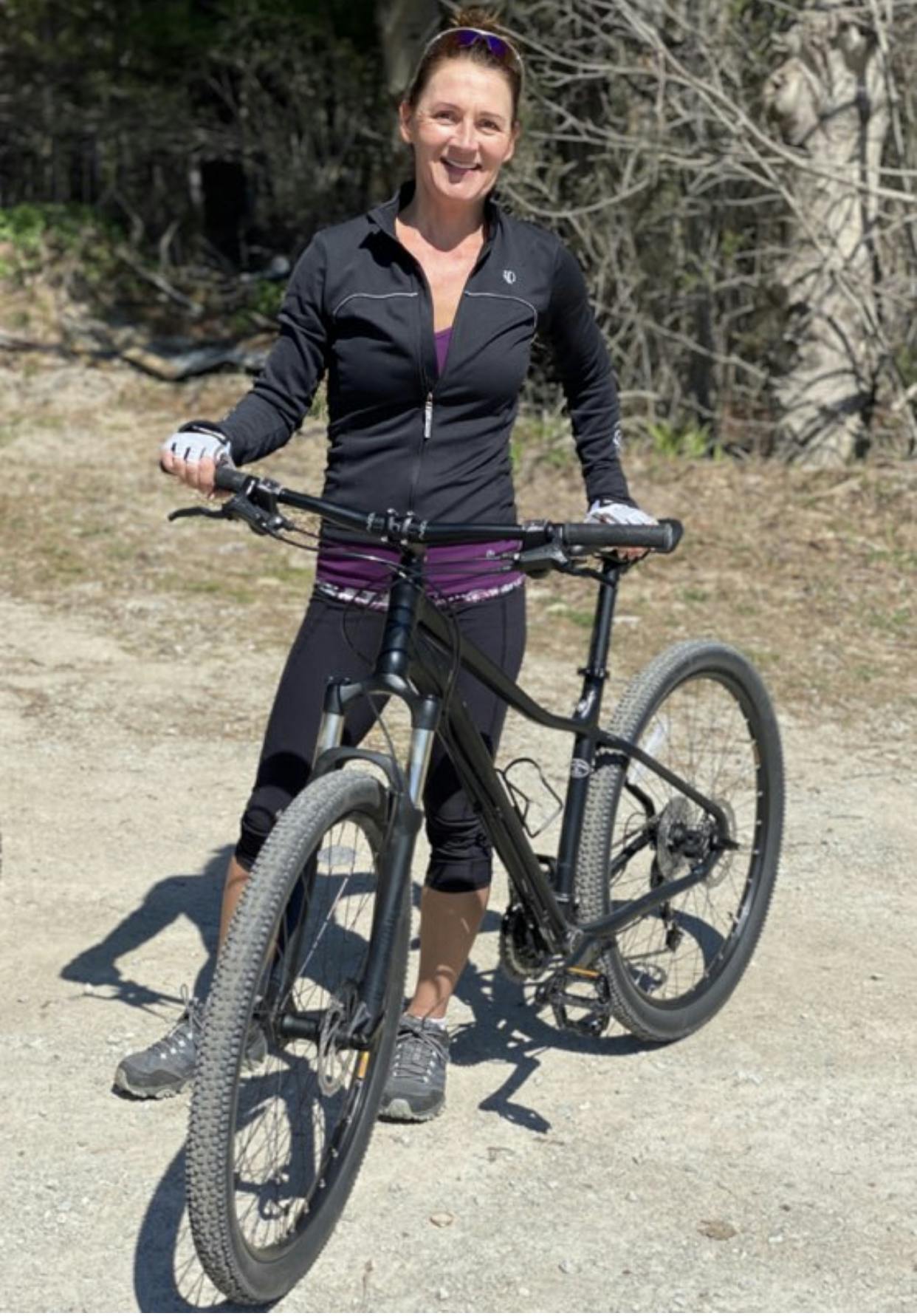 Anita Perrigo standing and holding her mountain bike