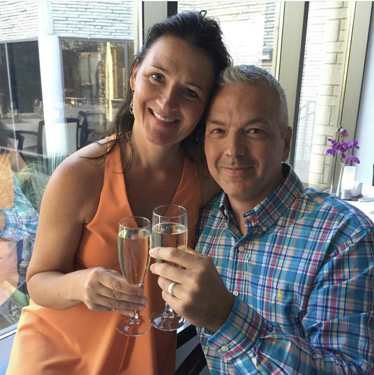 Anita and Brad Perrigo clinking champagne glasses 