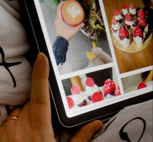 Person holding a tablet displaying desserts and coffee.