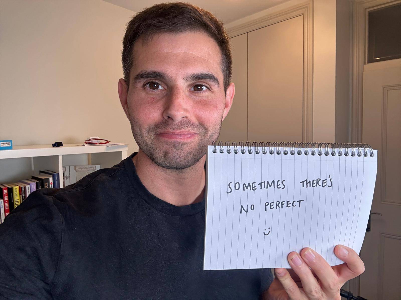 Me holding a sign saying sometimes there’s no perfect