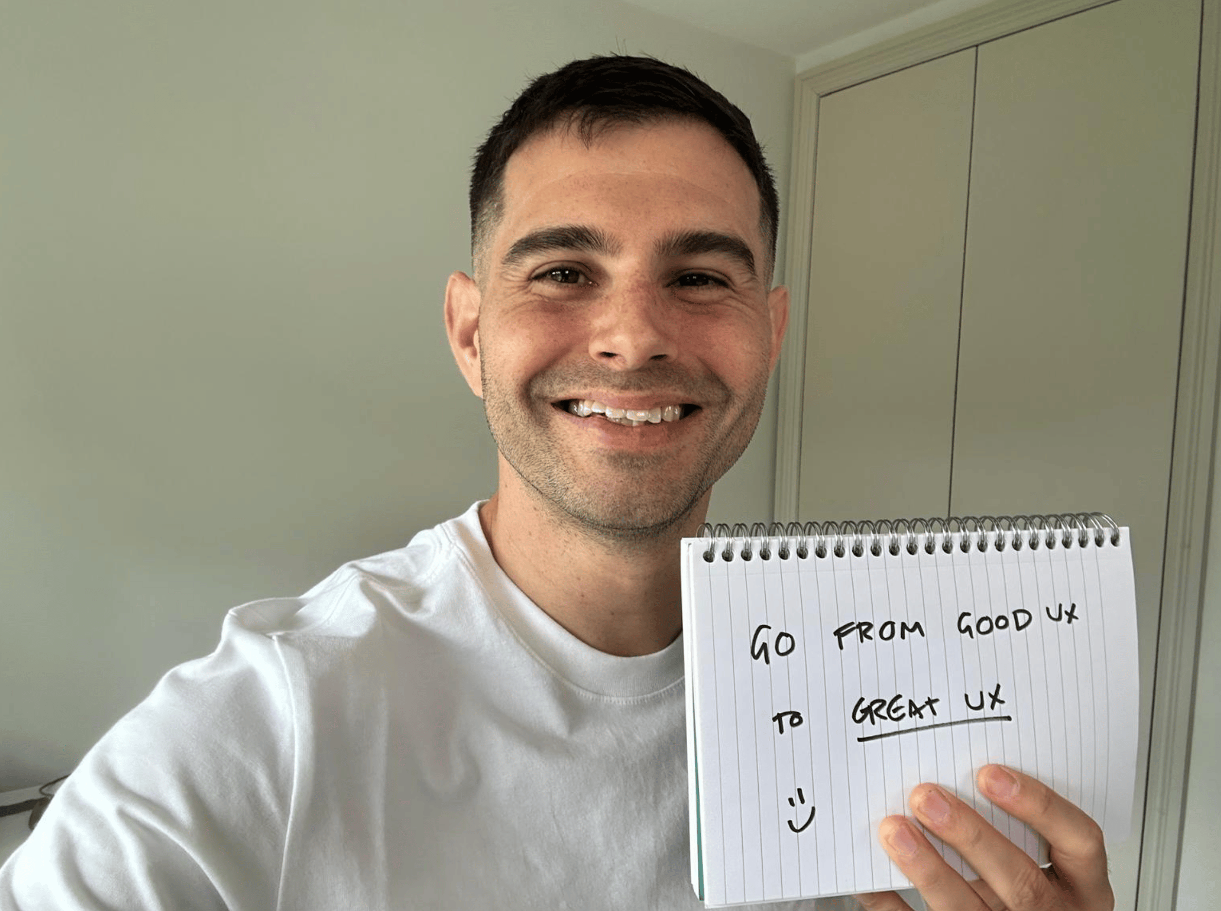 Me holding a sign saying, "Go from good UX to great UX."