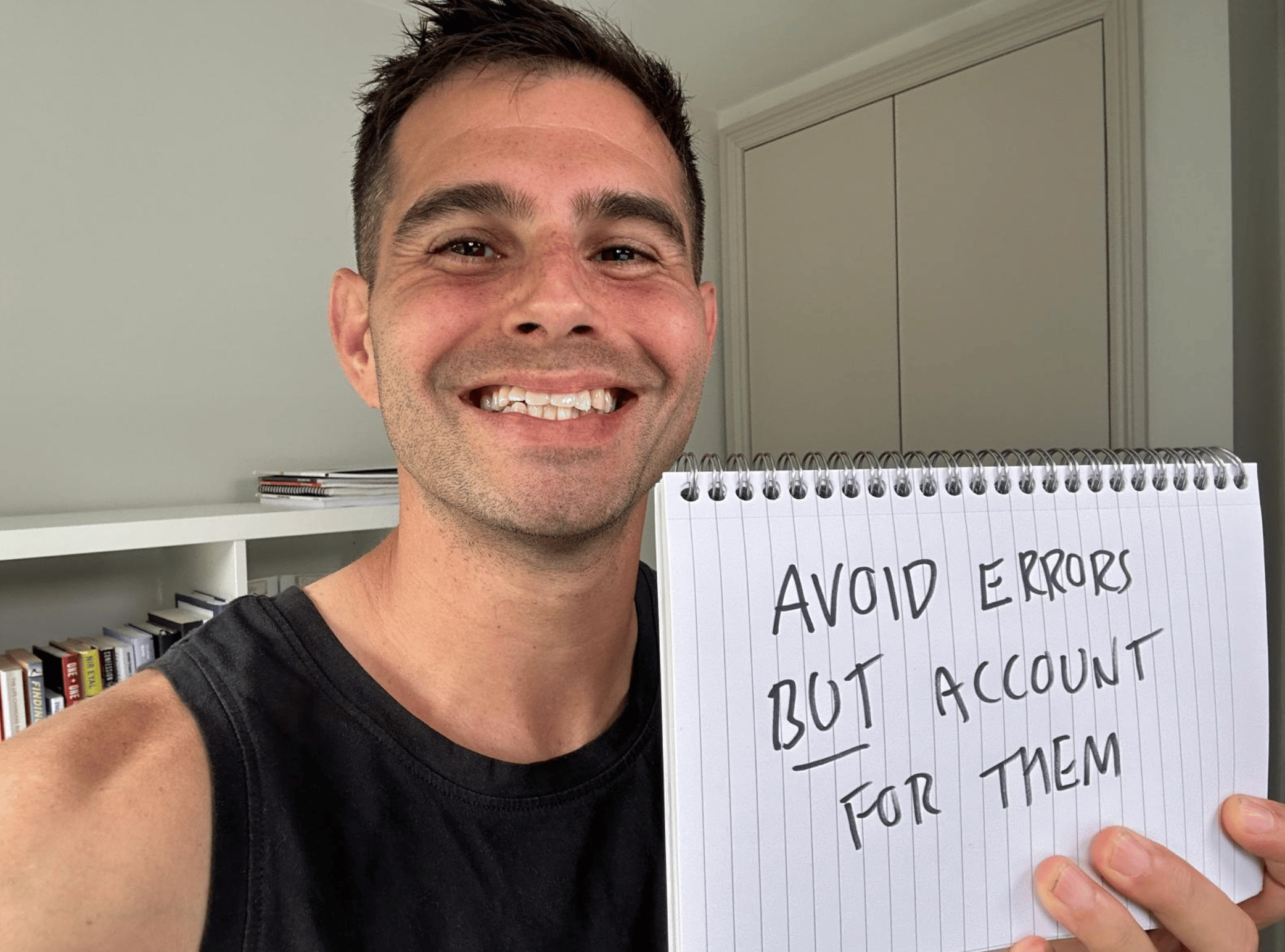 Me holding a sign saying “Avoid errors but account for them”