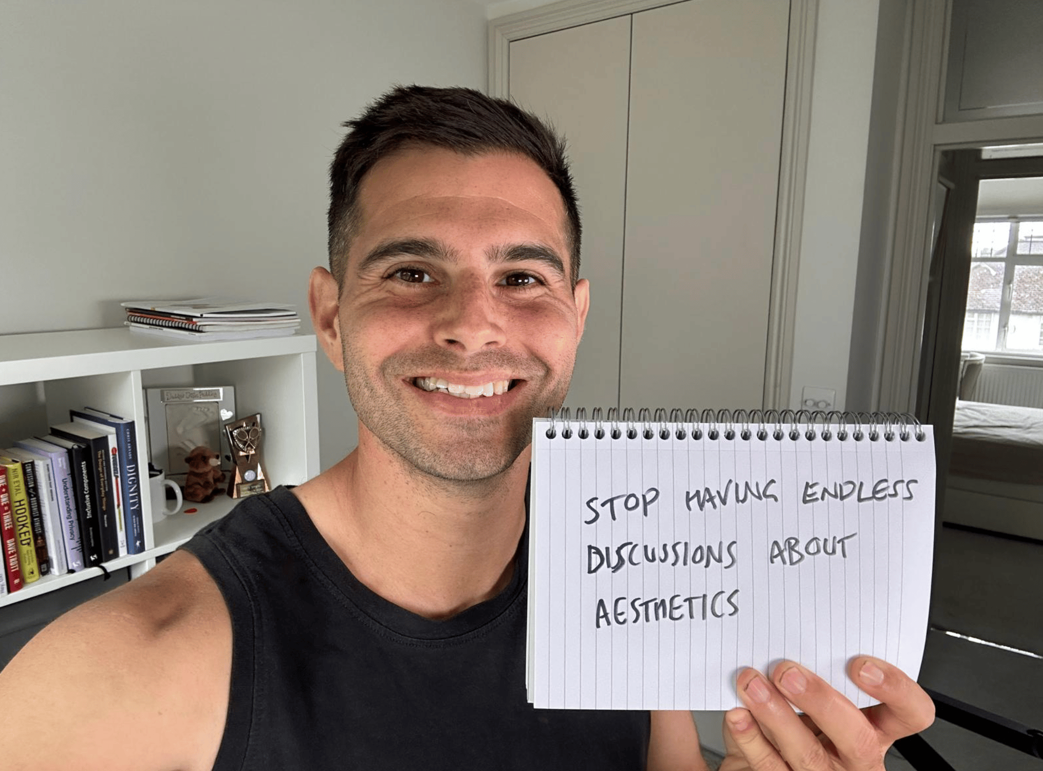 Me holding a sign saying stop having endless discussions about aesthetics