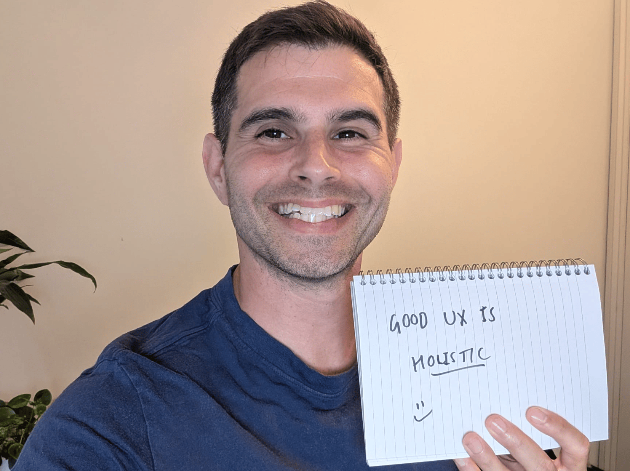 Me holding a sign that says, "Good UX is holistic."