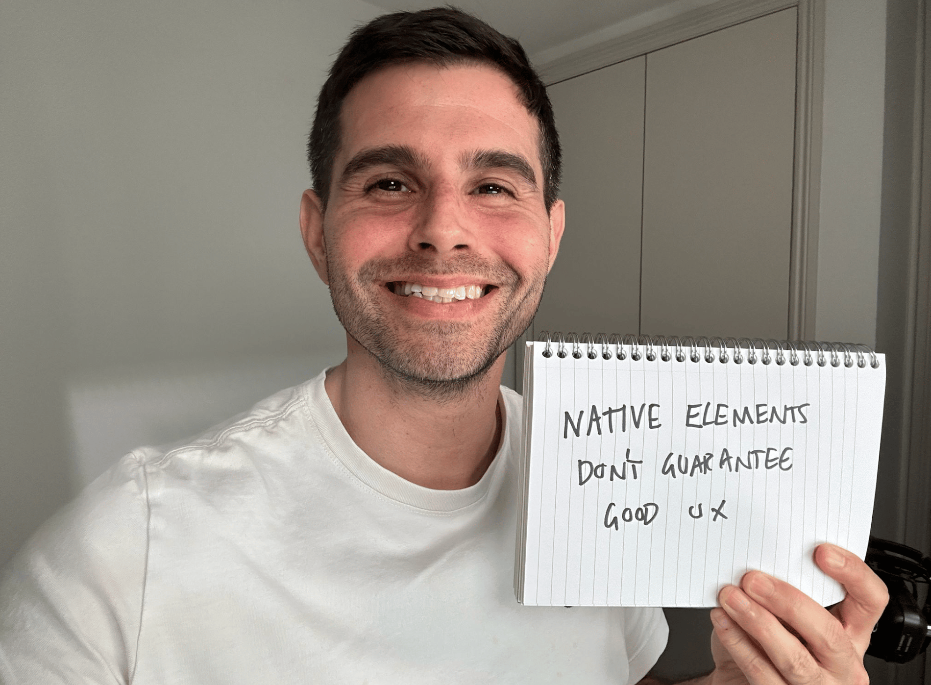 Me holding a sign saying native elements don't guarantee good UX.