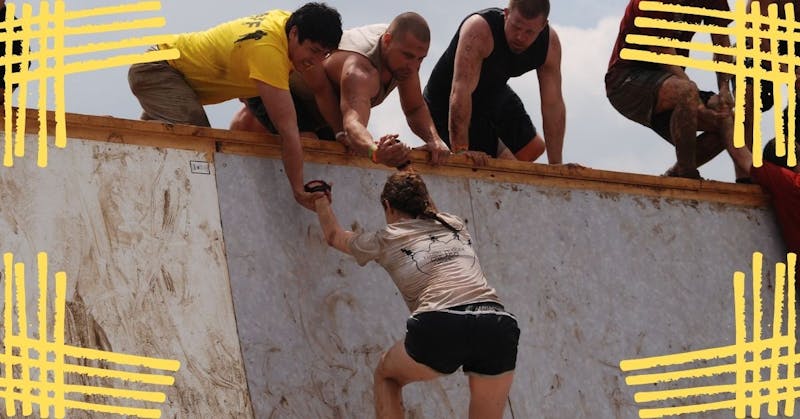 woman climbing wall in spartan race