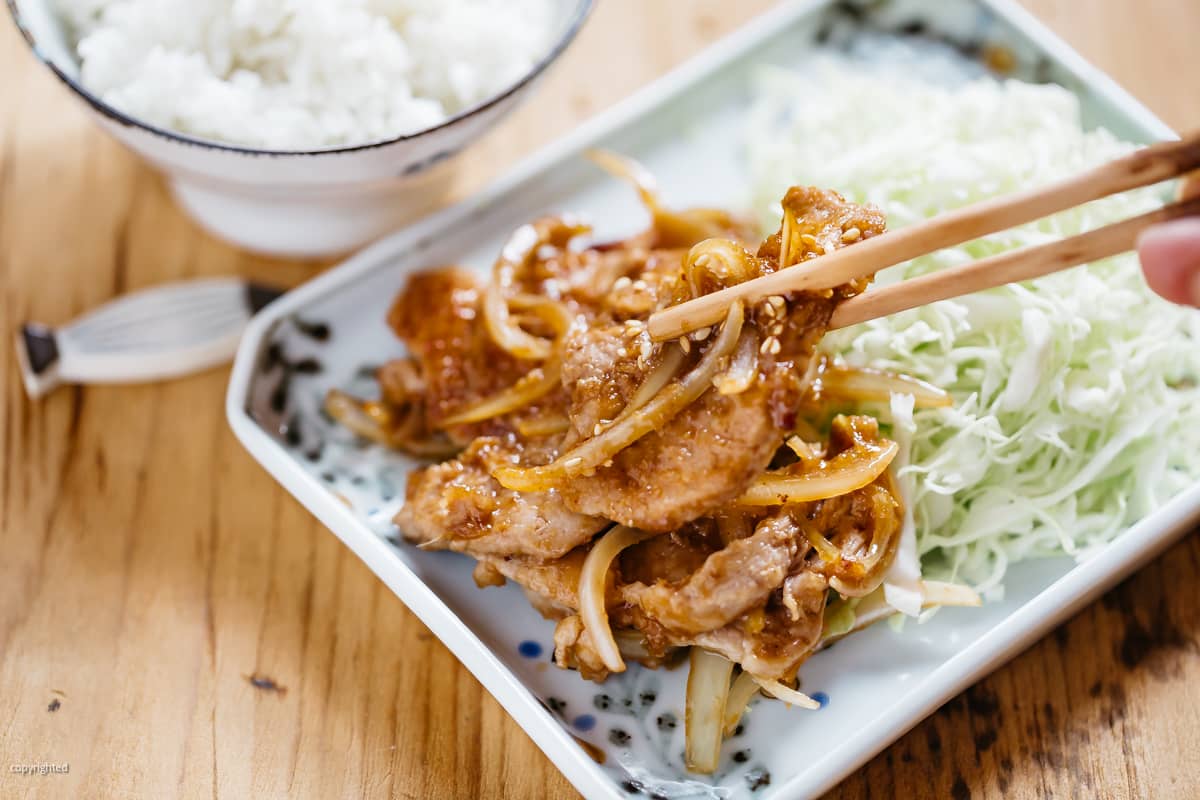 unadon served in a rice bowl with a pair of chopsticks 