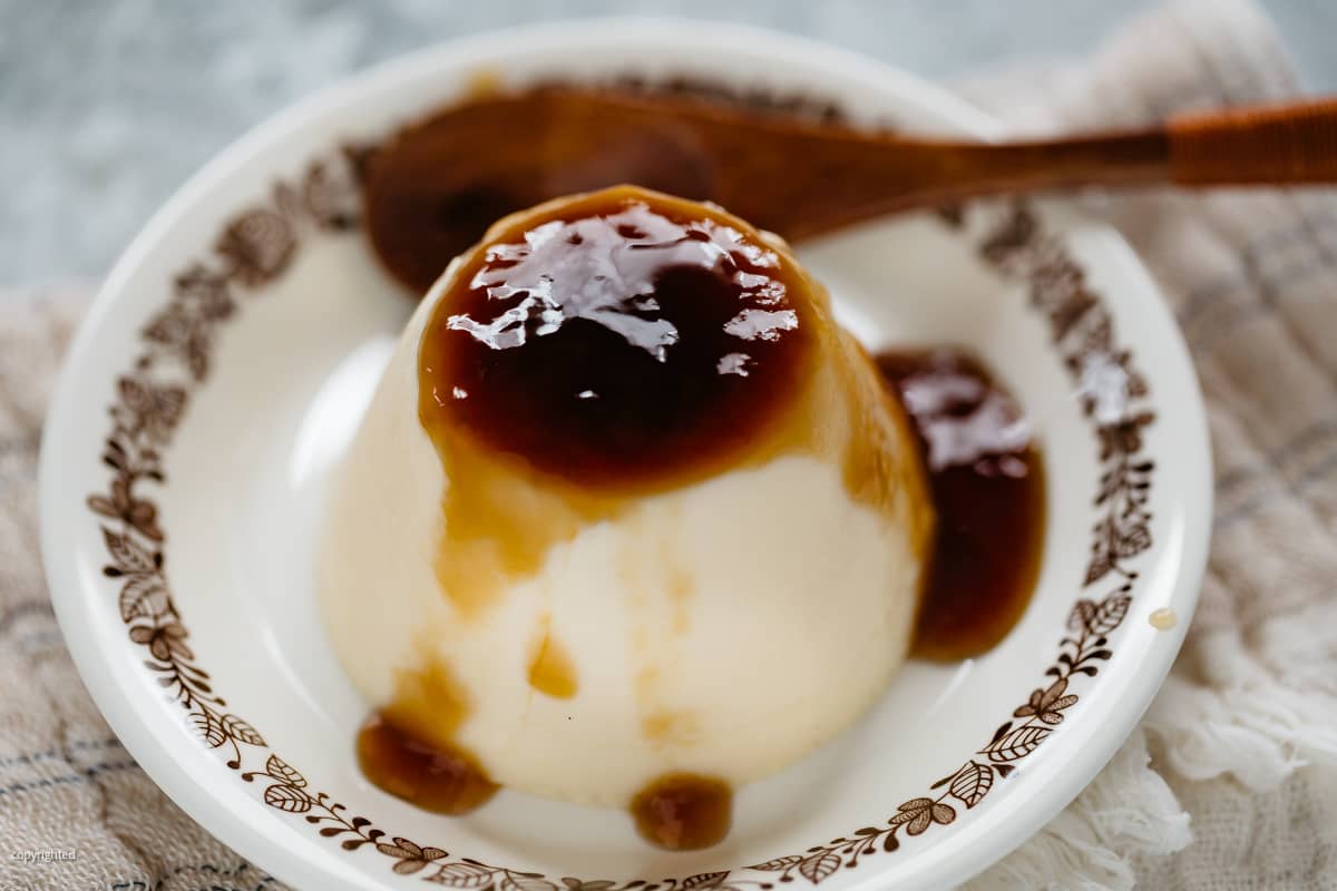 unagi sauce in a glass jar with a wooden spoon