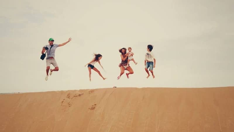 people jumping on sand