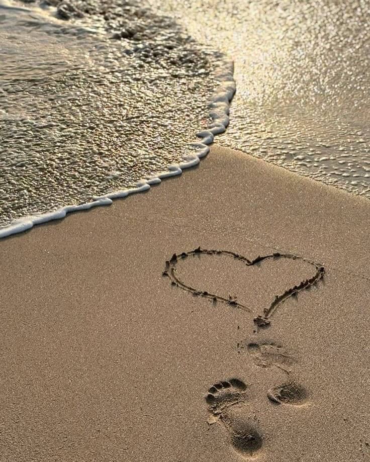 Image of a heart drawn in the sand near the water