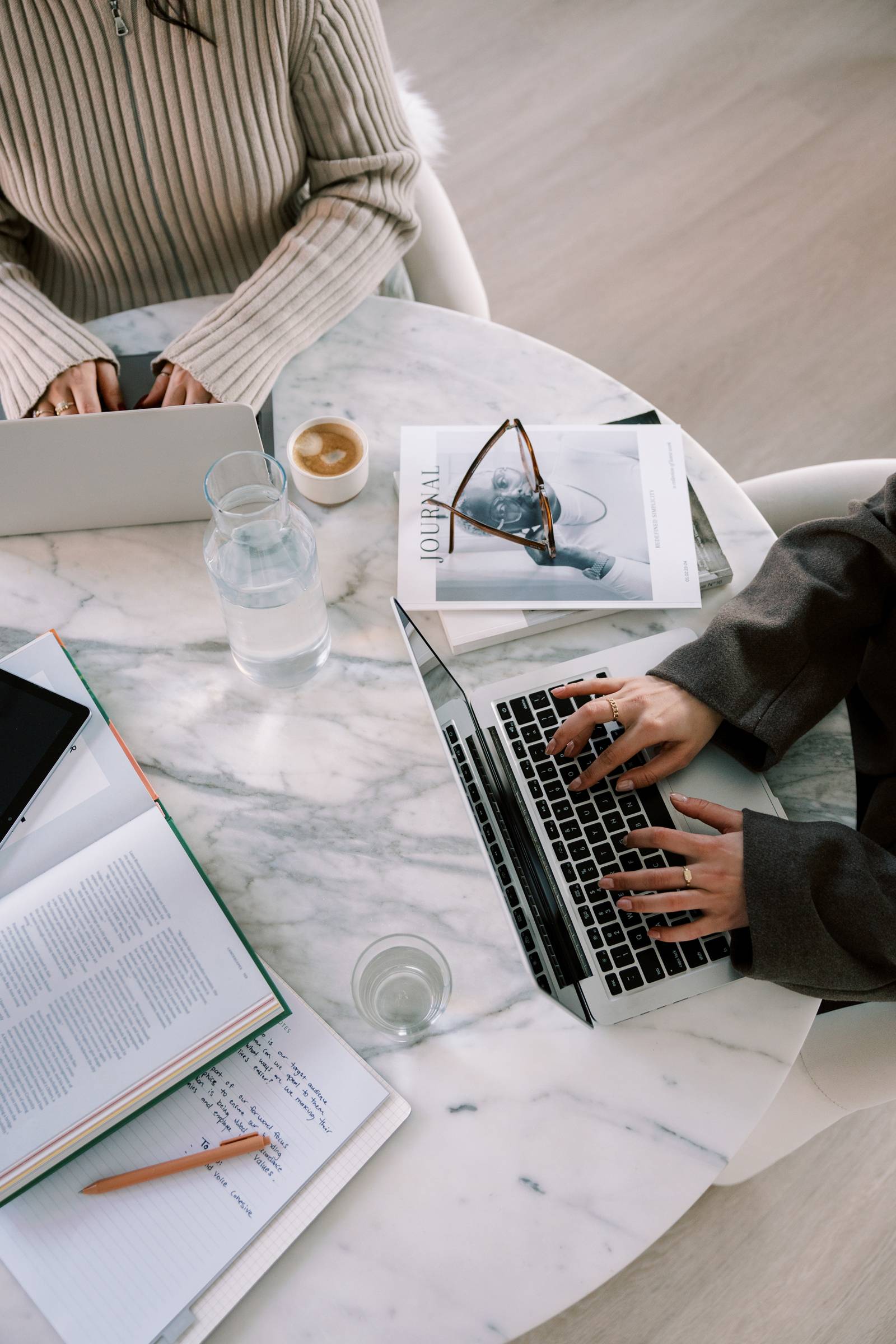 Flatlay image of 2 women typing on their computers