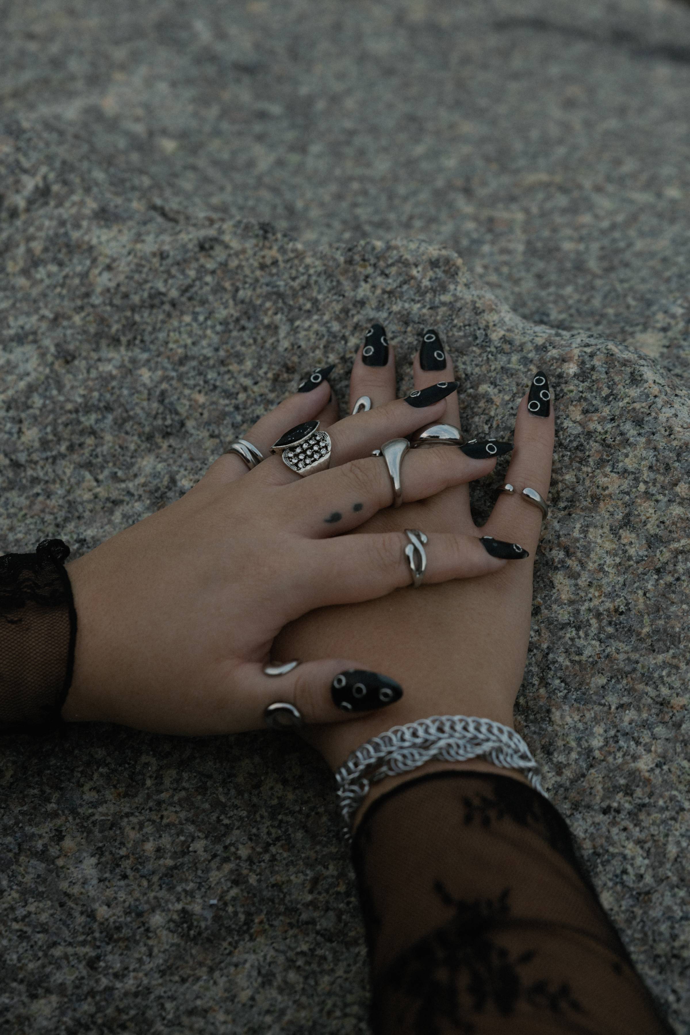 Image of my hands with rings on it resting on a rock