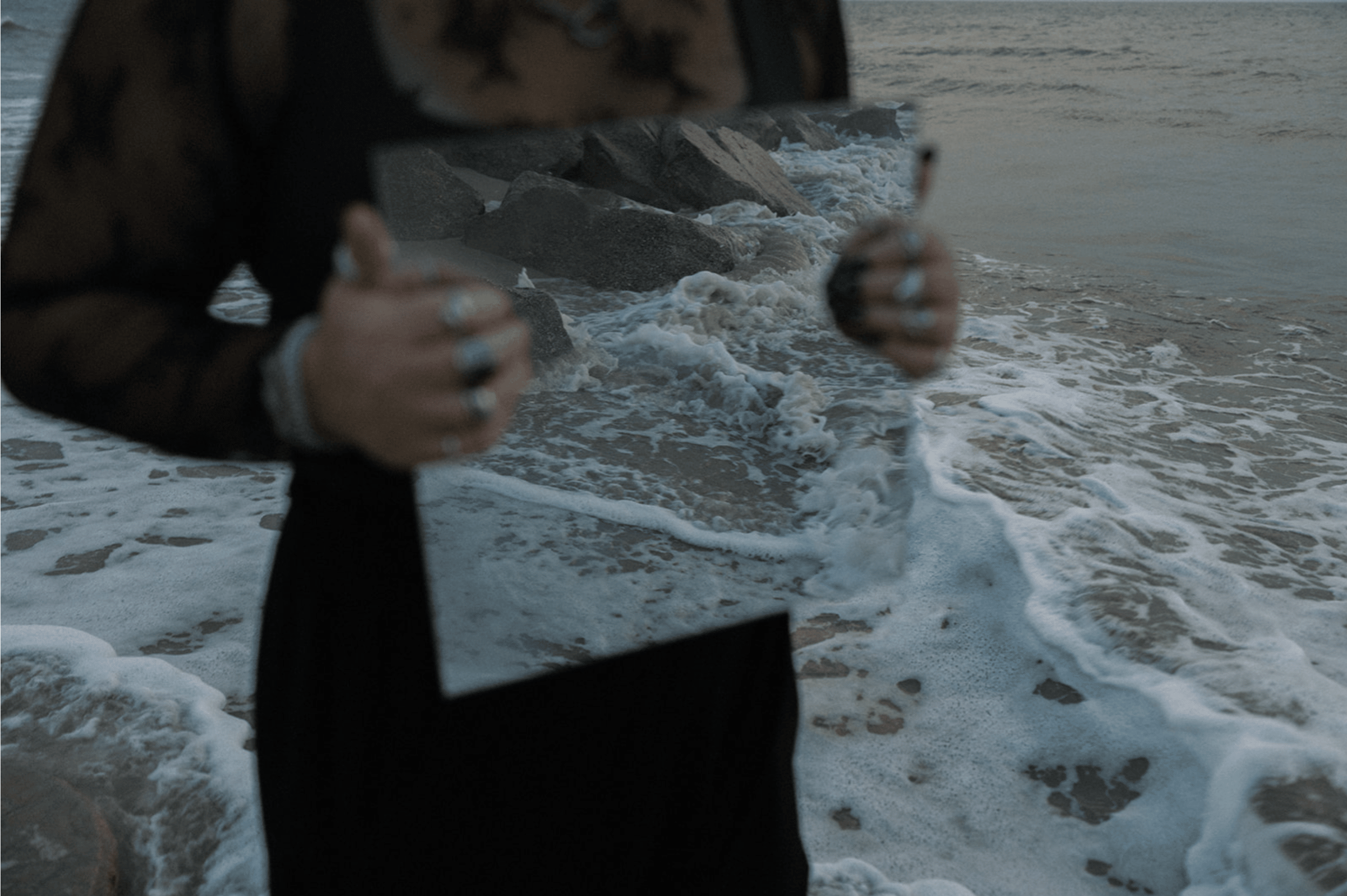 Image of me holding a mirror with the ocean in the background & reflecting