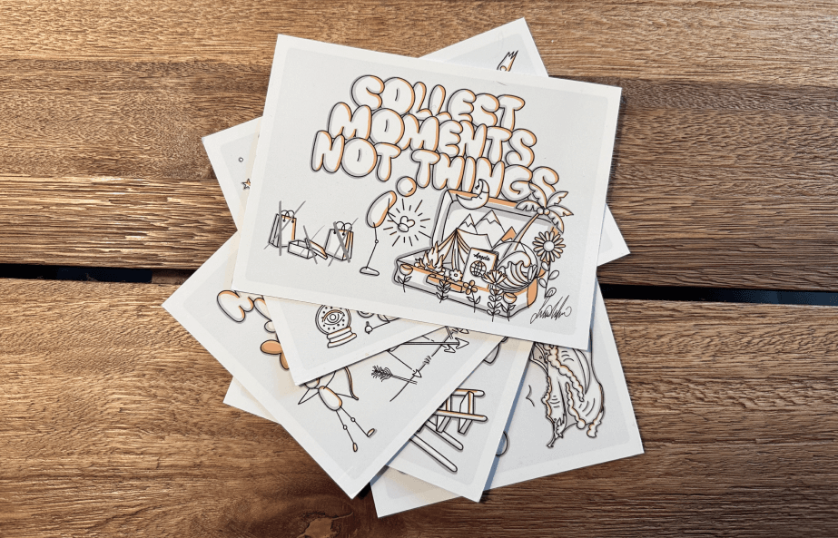 A photo of a stack of physical postcards with motivational phrases and illustrations like "Collect moments, not things"