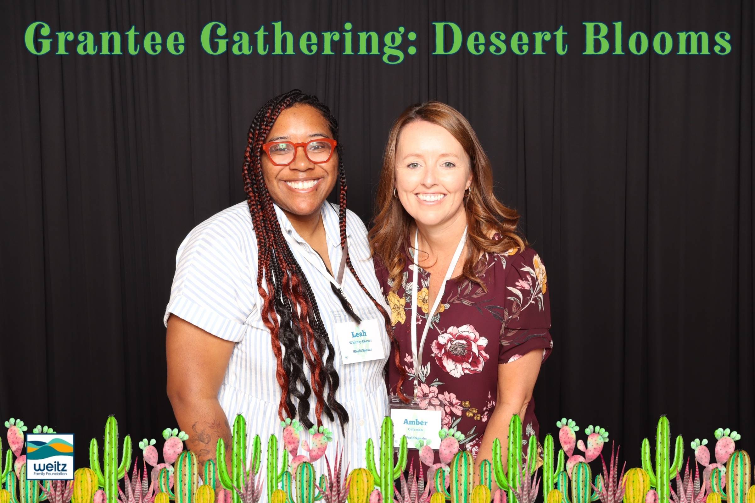 Two women smile at the camera in front of a black backdrop. Above them is text that reads "Grantee Gathering: Desert Blooms" 