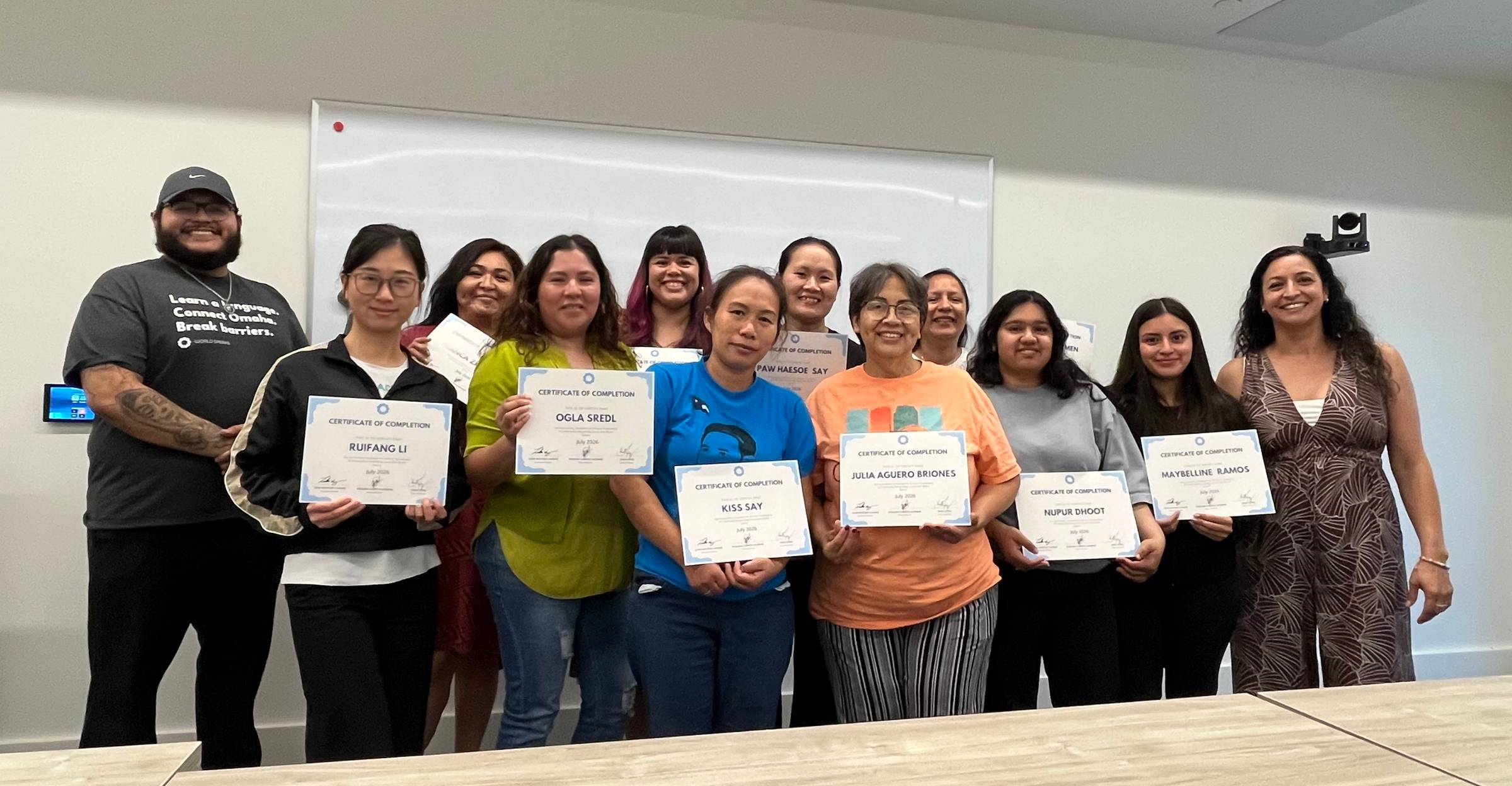 A group of individuals hold certificates and smile at the camera.