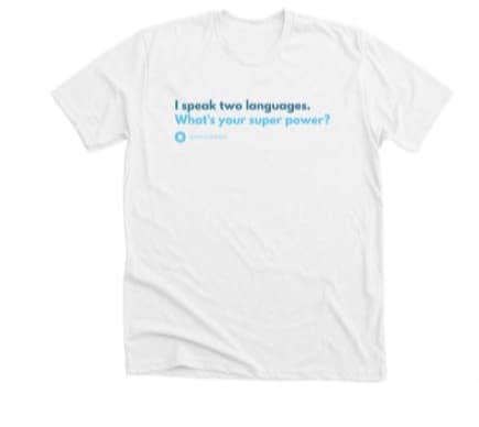 Image shows a white t-shirt with the words "I speak two languages. What's your superpower?" in two different shades of blue. 