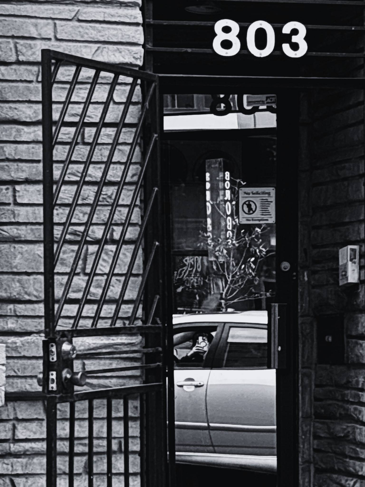 Black and white doorway with a reflection of a car in the glass